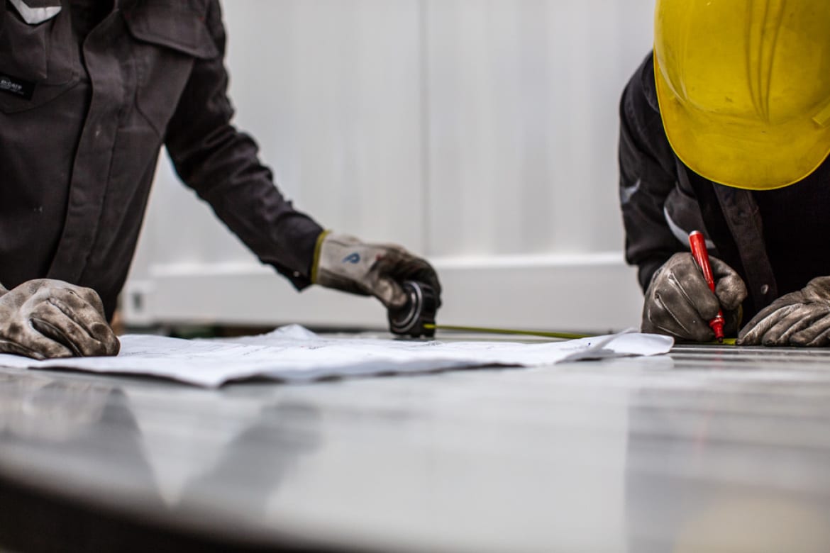 Dimensional check with tape measure on a steel panel against the drawing