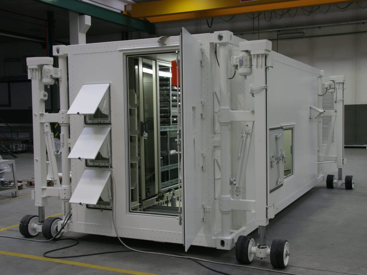 White mobile shelter unit on wheels with louvres and access doors